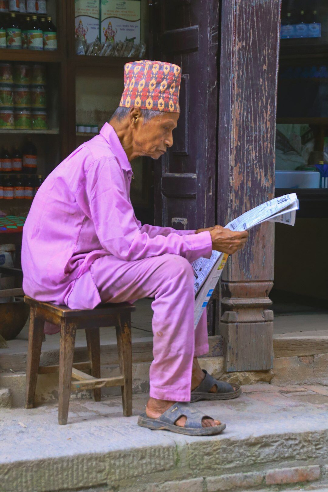 Elderly Japanese man reading a newspaper at home